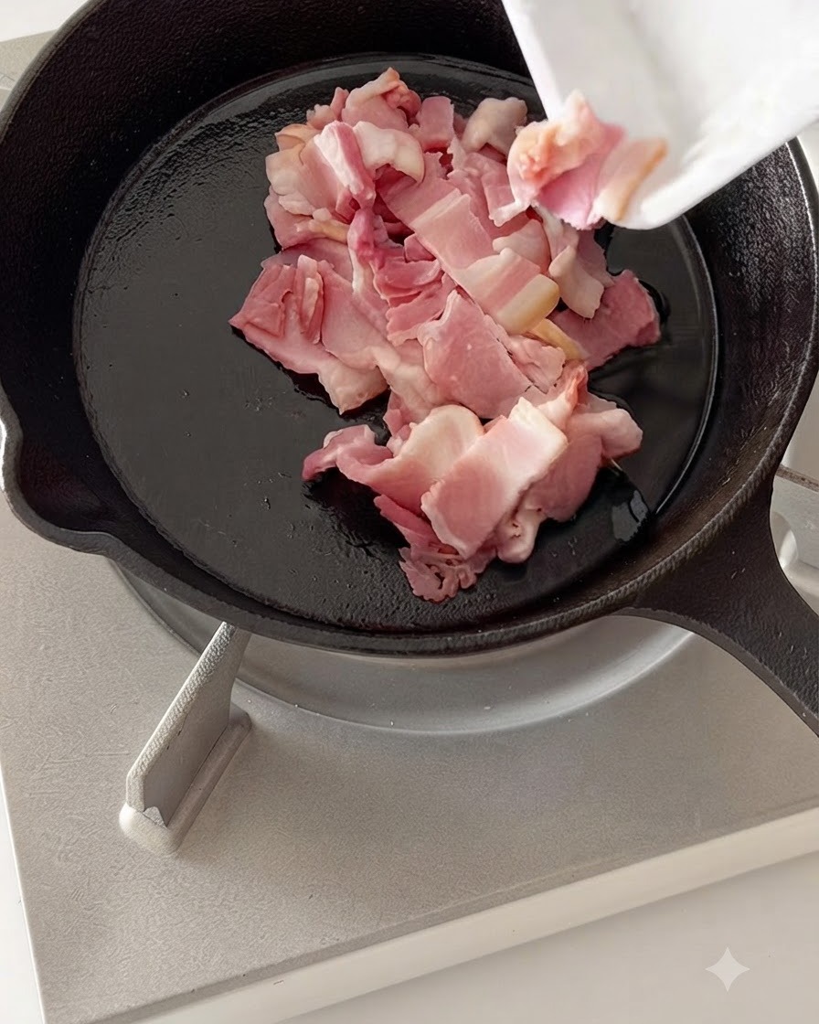 Gehackte Speckstücke braten in einer heißen Gusseisenpfanne.