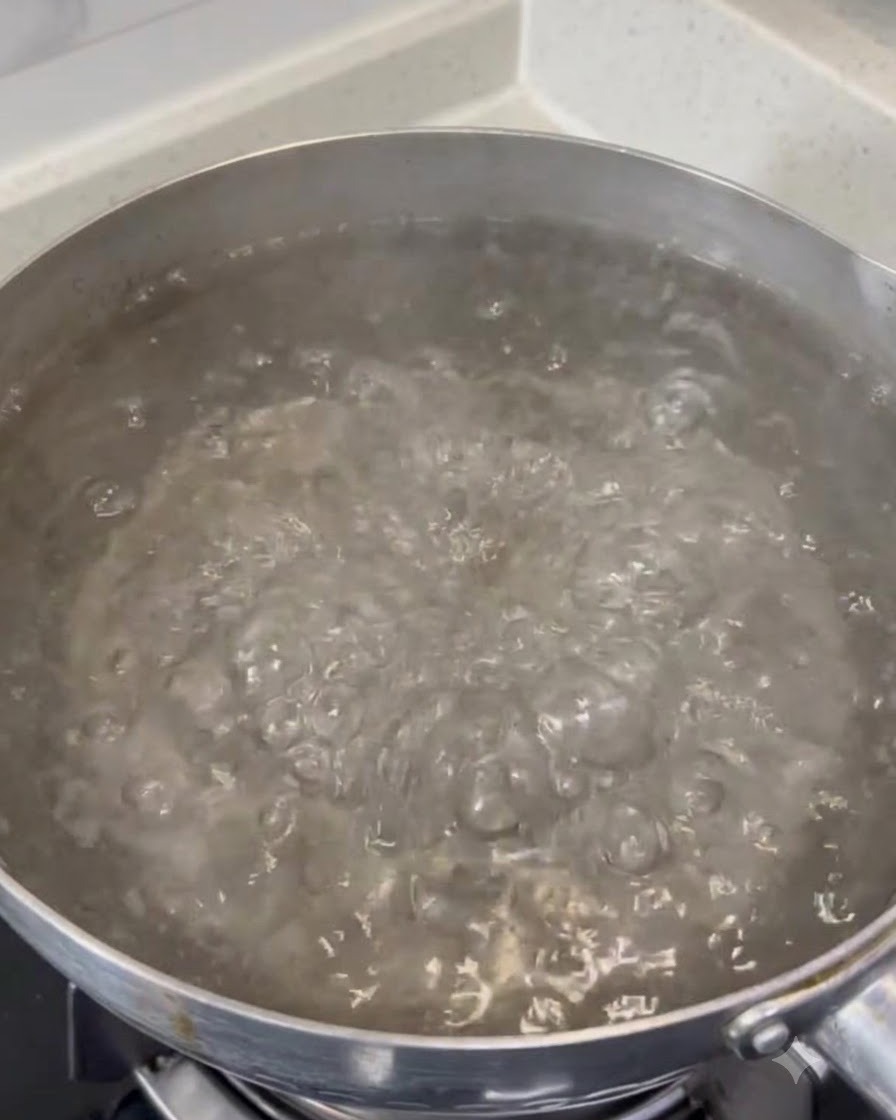 Grobes Salz löst sich in einem großen Topf mit sprudelnd kochendem Wasser auf.