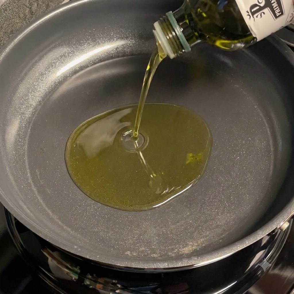 Olivenöl wird in eine Pfanne gegossen, um geschnittenen Knoblauch zu braten.