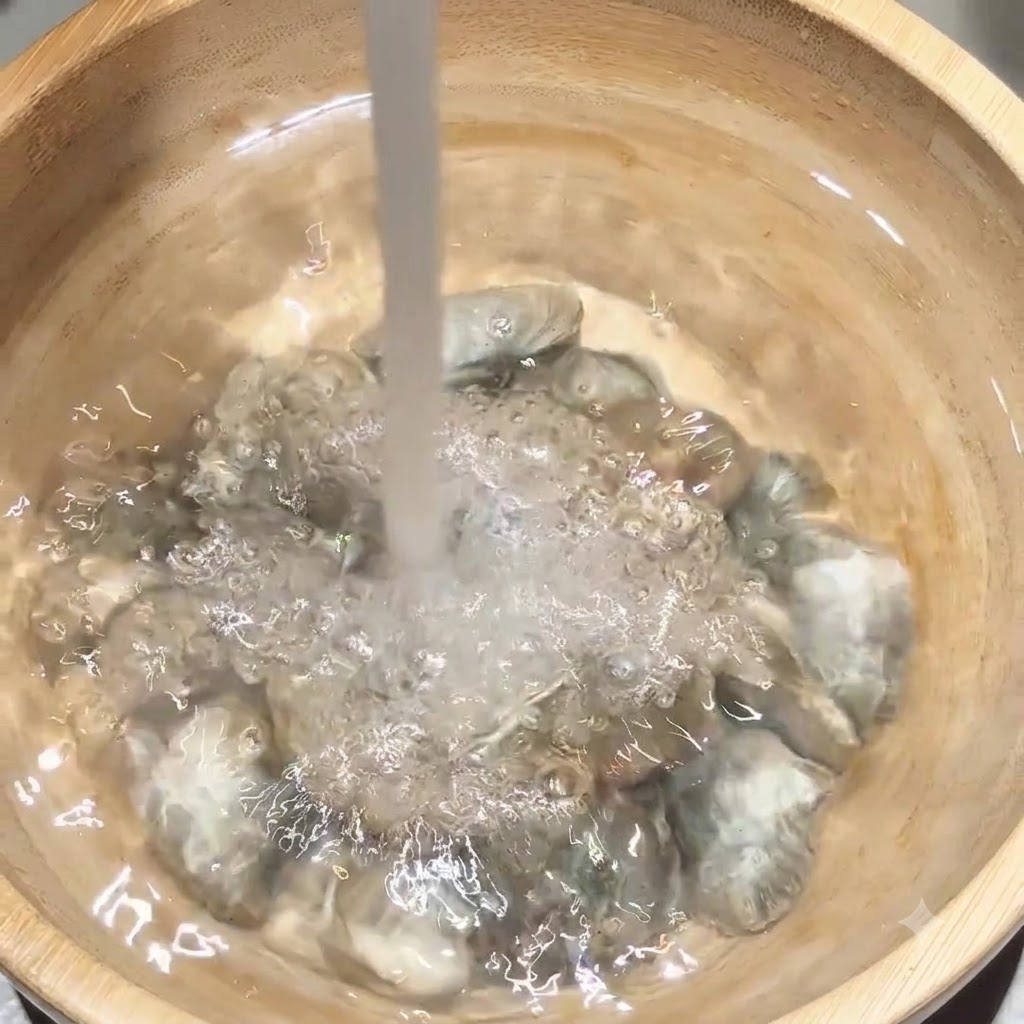 Frisches Wasser fließt direkt auf eine Portion Muscheln in einer Holzschüssel.