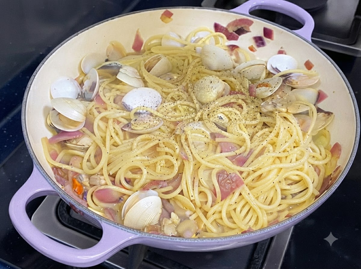 Frischer schwarzer Pfeffer wird über eine Pfanne mit gekochten Spaghetti und Muscheln gestreut.