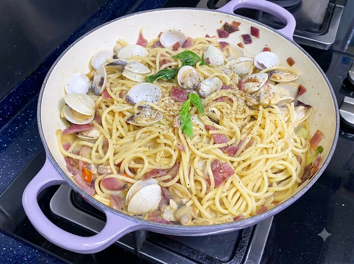 Frische grüne Basilikumblätter liegen auf fertigen Muschel-Spaghetti.