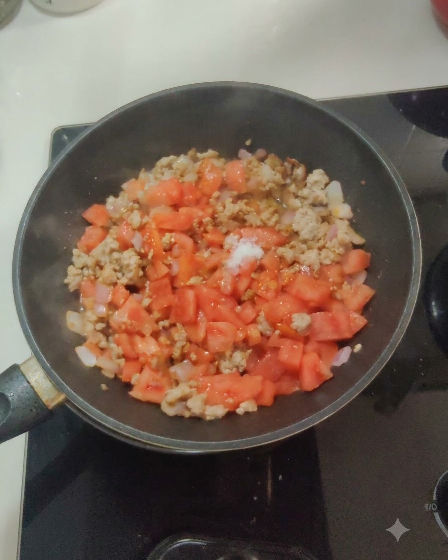 Weißes Salz und Zucker werden auf die Tomaten-, Zwiebel- und Fleischmischung in einer Pfanne gestreut.