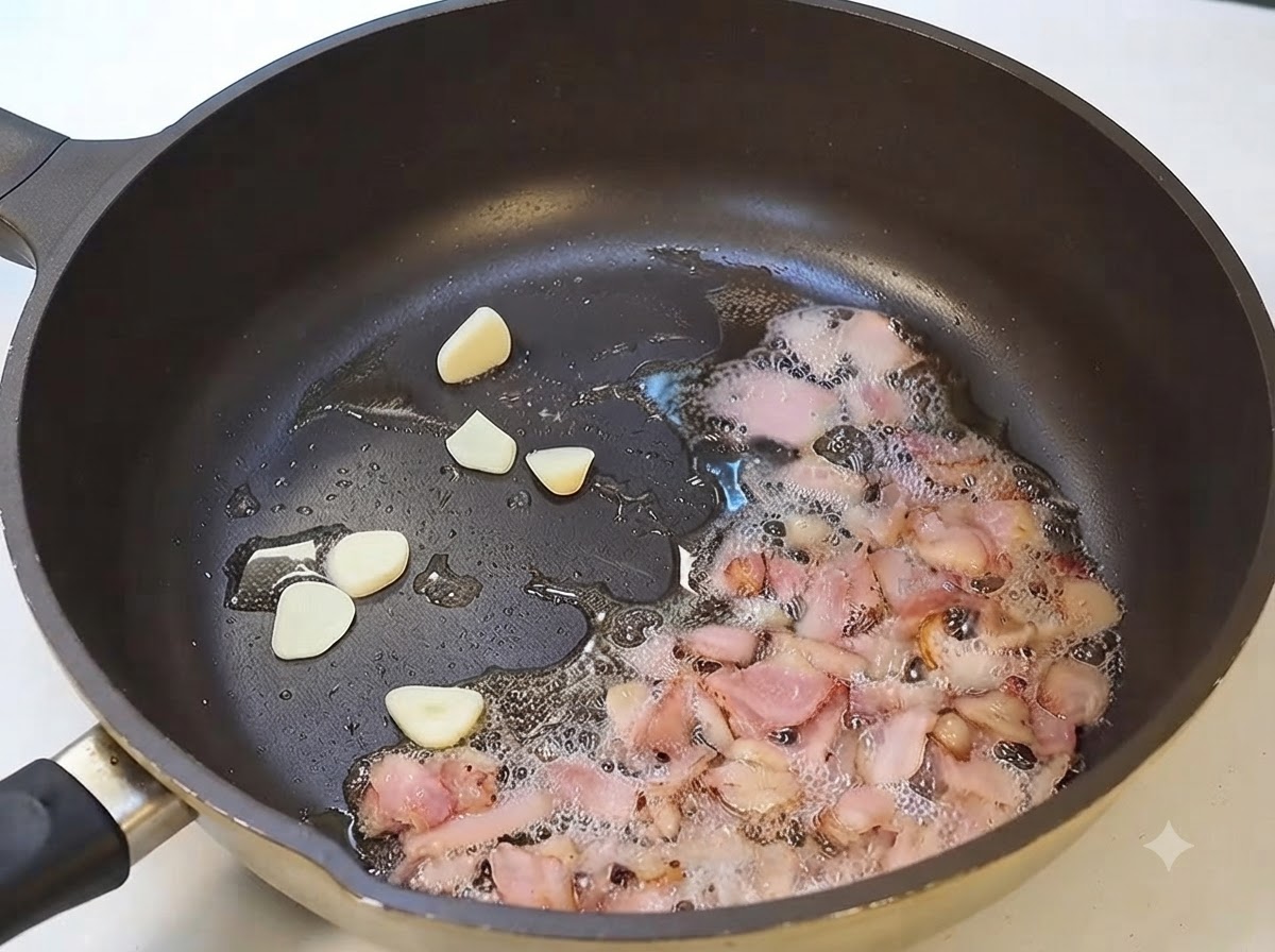 Knoblauchscheiben und Speck braten zusammen in einer Pfanne.