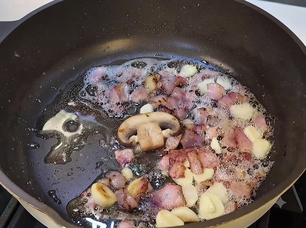 Geschnittene Pilze garen in der Pfanne mit Speck und Knoblauch.