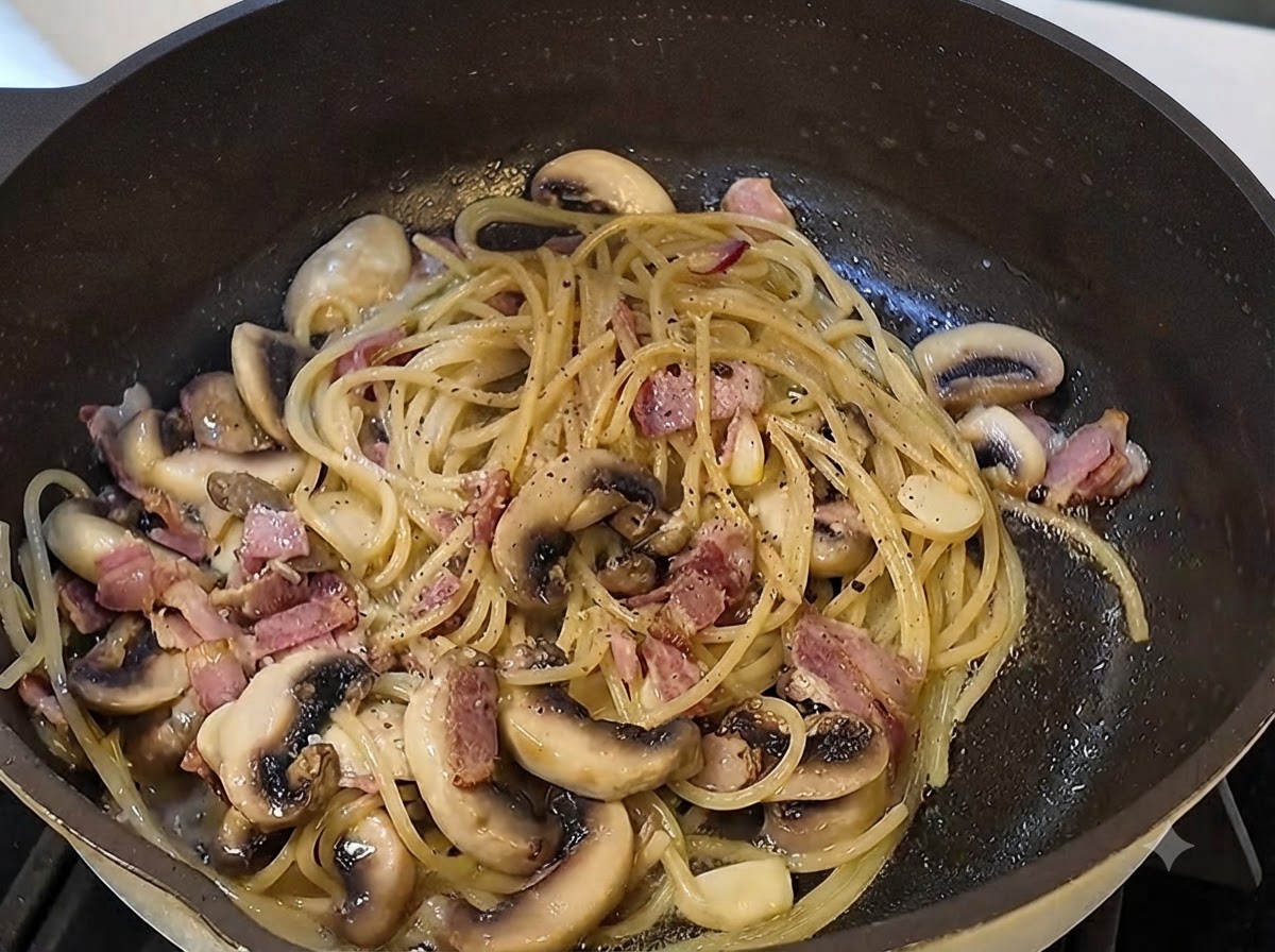 Schwarze Trüffelsauce und frisch gemahlener schwarzer Pfeffer werden in die Pastapanne gegeben.