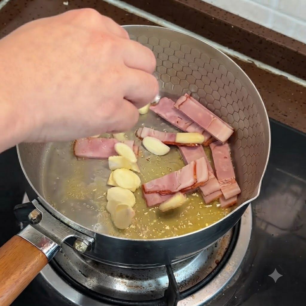 Geschnittener Speck und Knoblauchstücke werden in einer Pfanne mit geschmolzener Butter angebraten.
