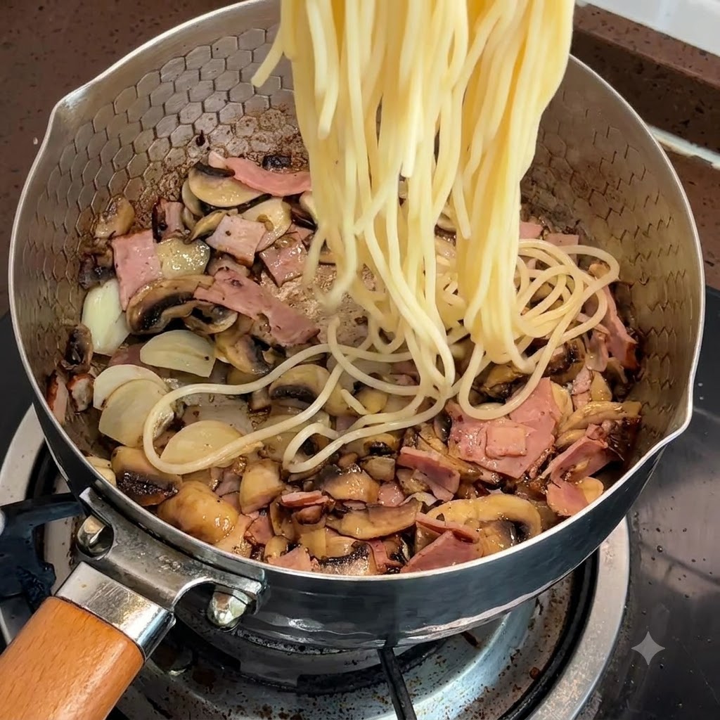 Gekochte Spaghetti werden in die Pfanne mit Speck und Pilzen gegeben.