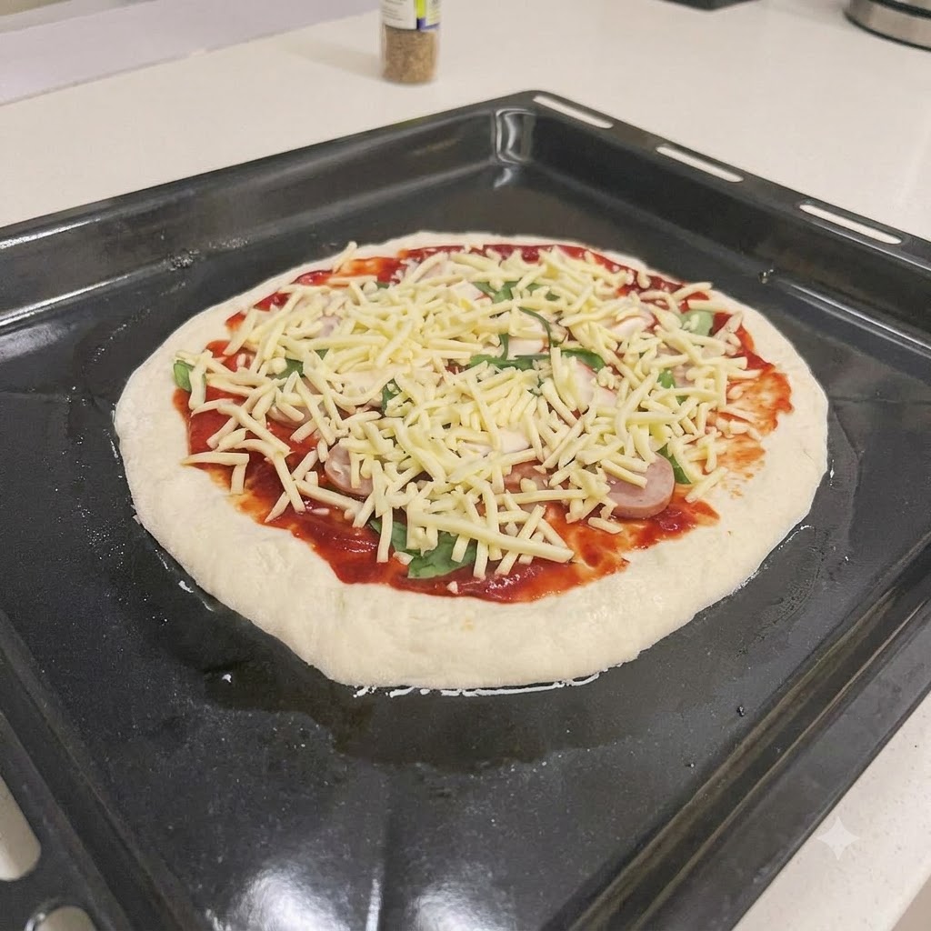 Eine ungebackene Pizza mit roter Sauce, Wurst, Basilikum und Käse auf einem Backblech.