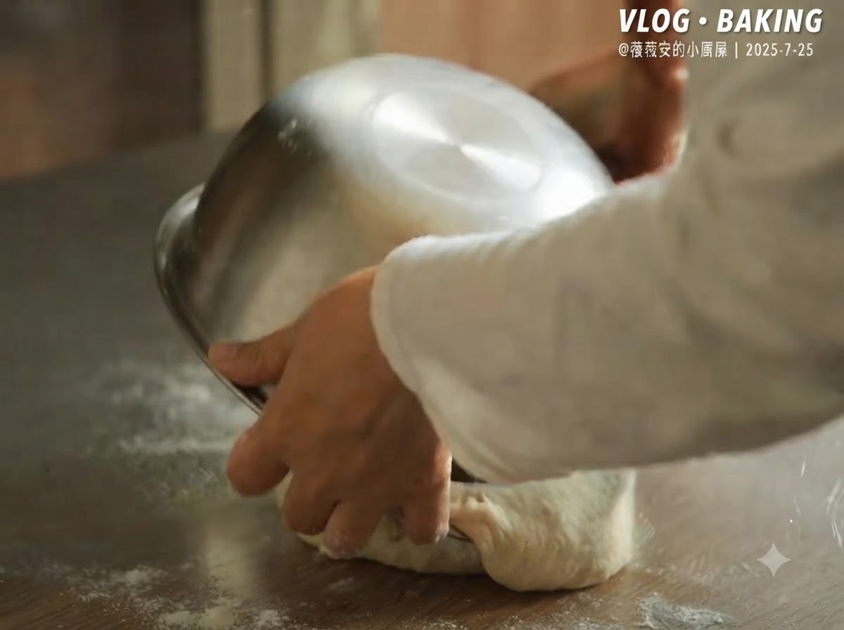 Eine Metallschüssel wird umgedreht, um den fermentierten Pizzateig auf eine bemehlte Arbeitsfläche zu stürzen.
