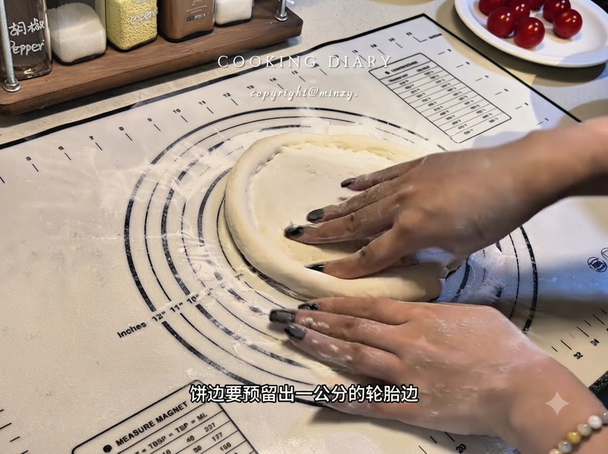 Hände formen die Ränder eines flachen Pizzateigs auf einer Silikonmatte zu einem erhabenen Rand.