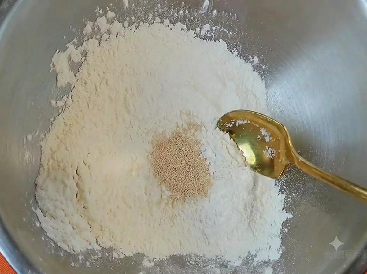 Eine Metallschüssel mit Mehl, einem Haufen Hefe und einem goldenen Löffel darin.