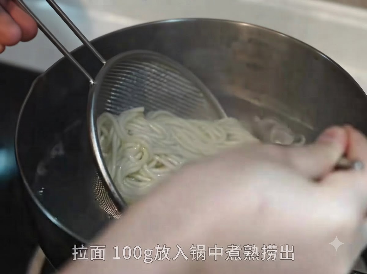 Gekochte Ramen-Nudeln werden mit einem Metallsieb und Essstäbchen aus einem Topf mit kochendem Wasser gehoben.
