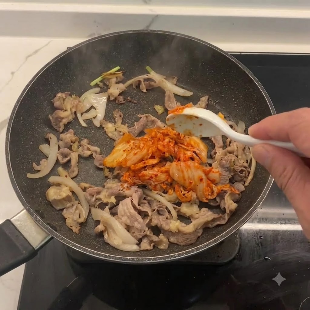 Gehacktes Kimchi wird in der Pfanne mit Rindfleisch und Zwiebeln vermischt.