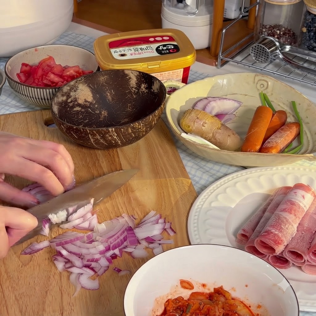 Rote Zwiebel wird auf einem Holzschneidebrett fein in kleine Stücke gehackt.