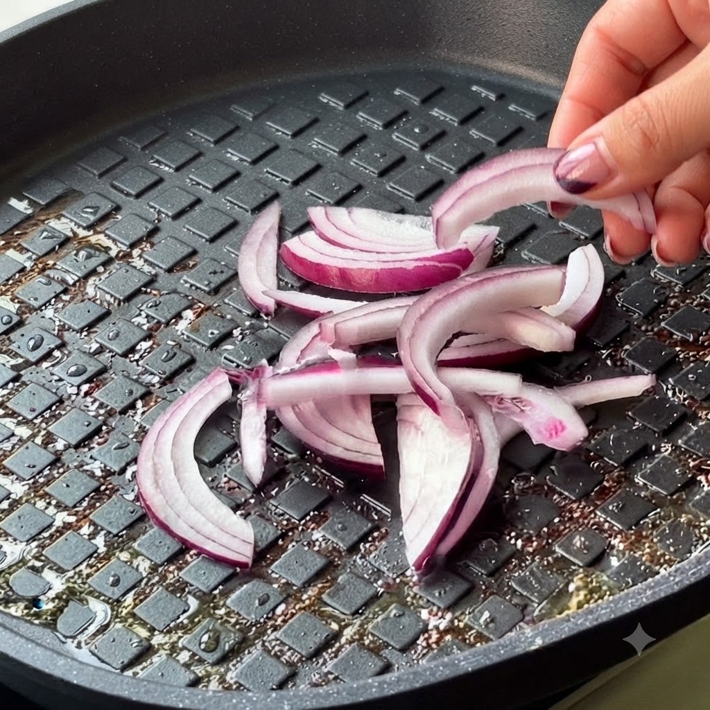 In Ringe geschnittene rote Zwiebel und Kimchi werden in die Pfanne gegeben.