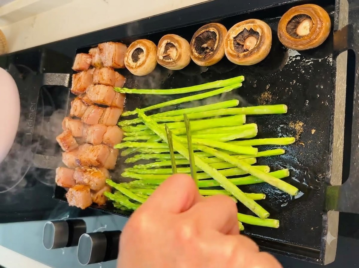 Maiskolben und Kirschtomatenrispen sind auf der Grillpfanne angeordnet.