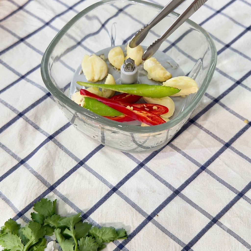 Chilischoten werden im Zerkleinerer zu einer Paste zerkleinert.