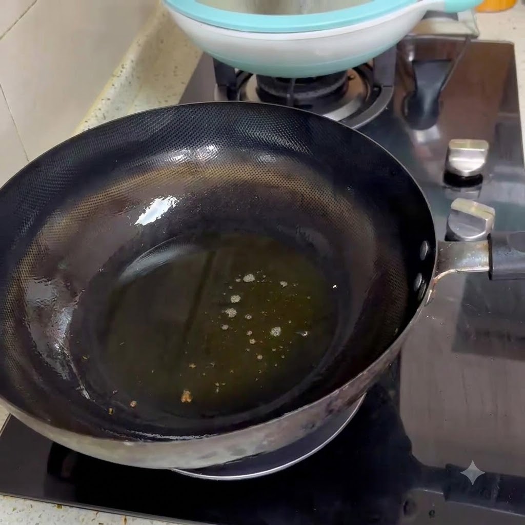 Zwei Löffel scharfe Bohnenpaste braten in heißen Öl in einem schwarzen Wok.