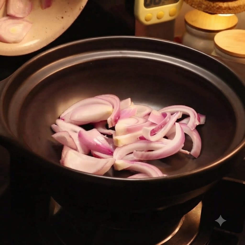 Frische Chinakohlblätter werden im schwarzen Topf über die roten Zwiebelscheiben gelegt.