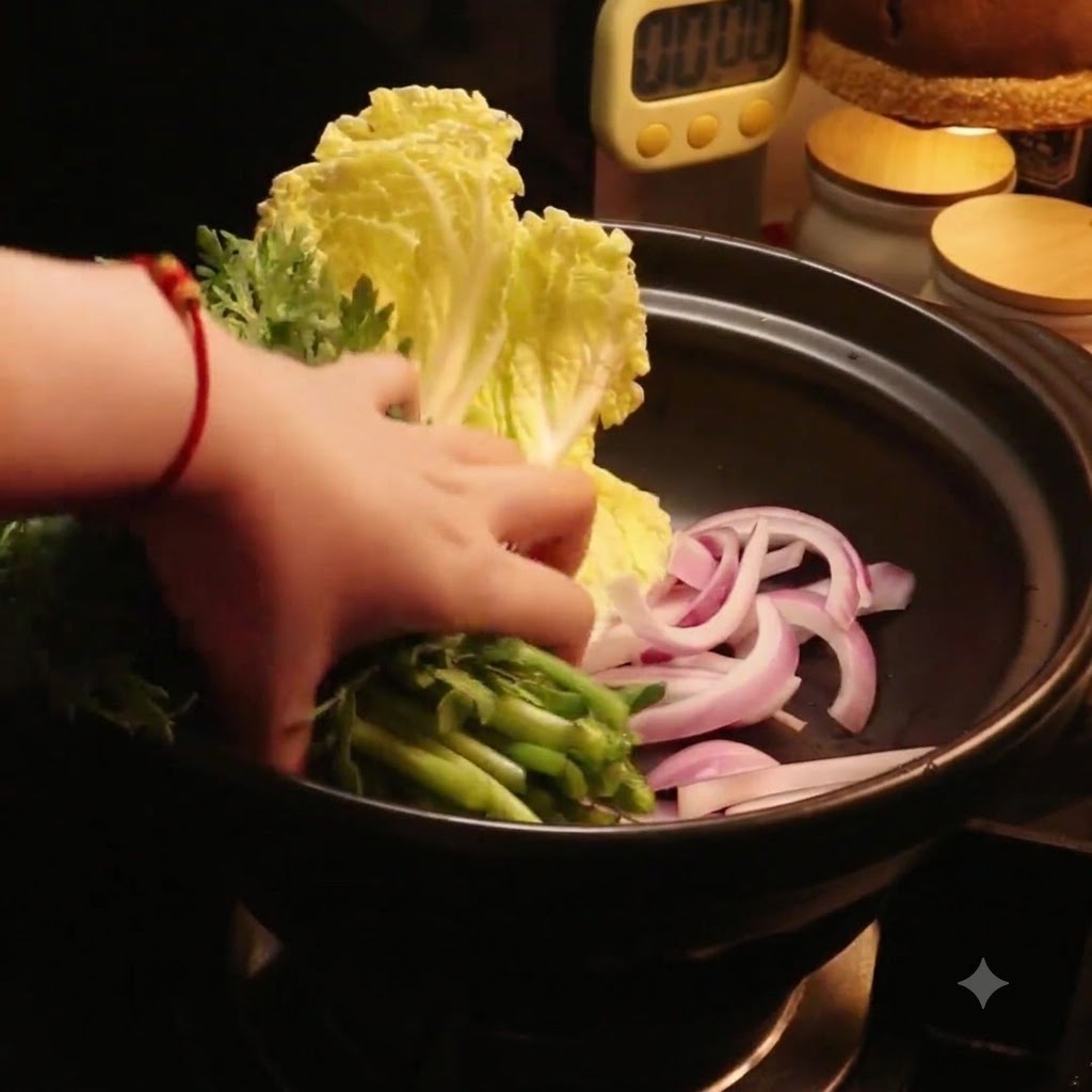 Eine Hand legt frisches grünes Gemüse neben den Kohl in den Topf.
