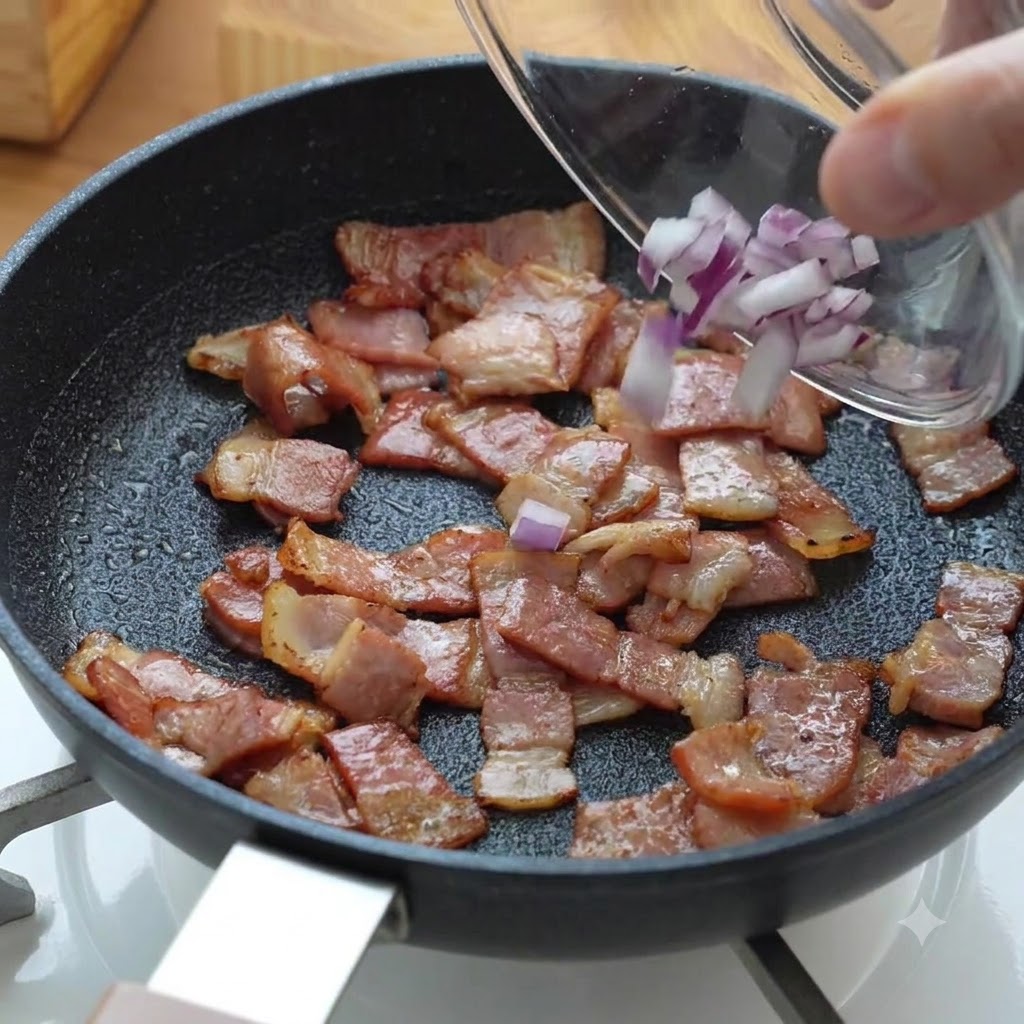 Gehackte rote Zwiebelstücke werden zu dem bratenden Bacon in die Pfanne gegeben.