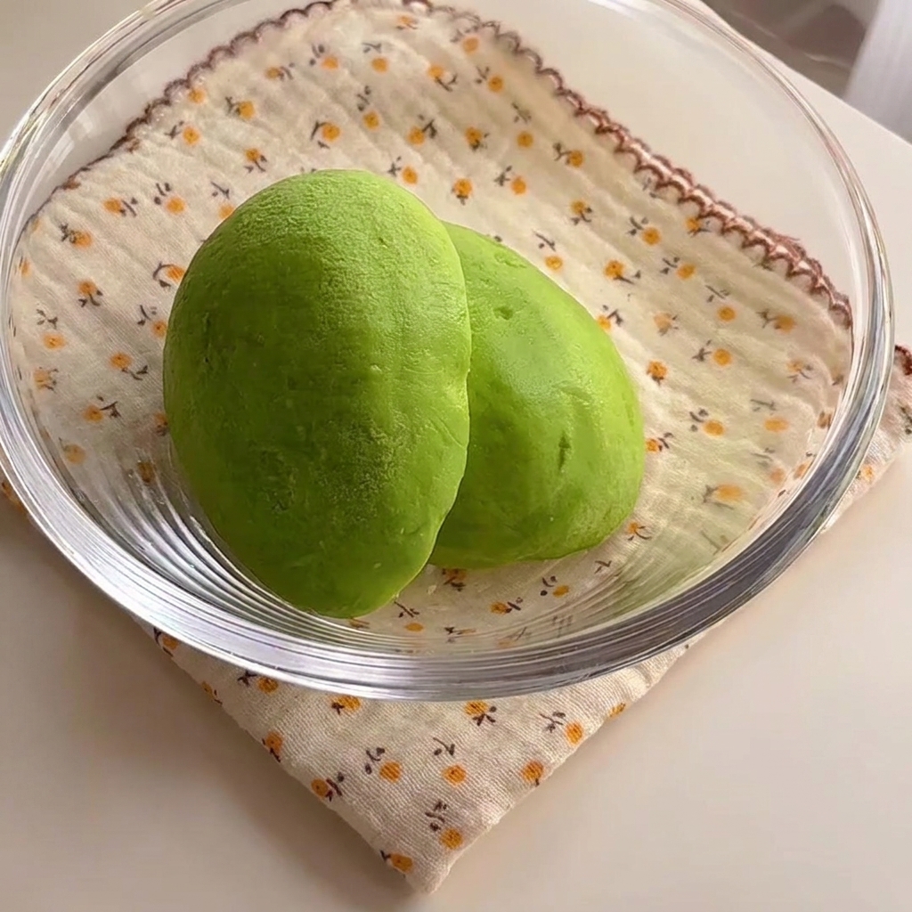 Zwei leuchtend grüne Avocadohälften in einer Glasschüssel.