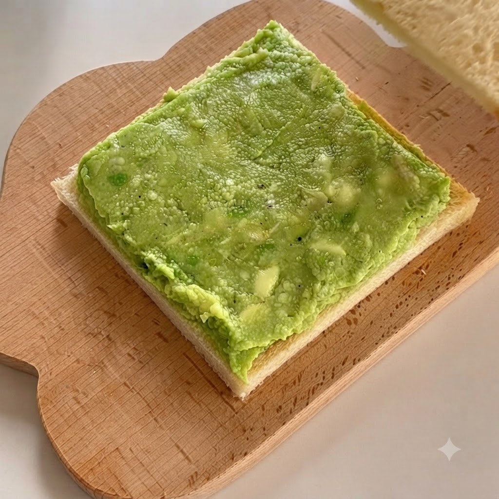 Eine zweite Weißbrotscheibe wird direkt auf die geschichtete Avocadopaste gelegt.