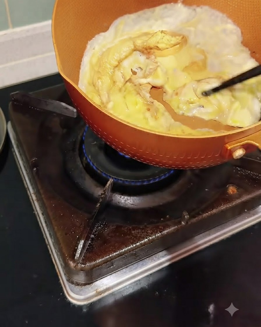 In einer Pfanne garen Eier, die mit Essstäbchen vorsichtig geschoben und verrührt werden.
