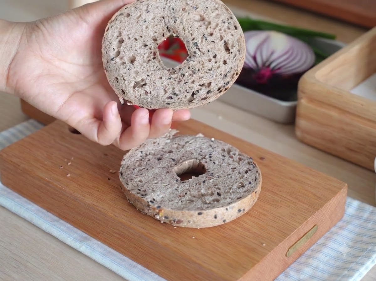 Zwei Bagelhälften in einem kleinen weißen Backofen während des Backens.