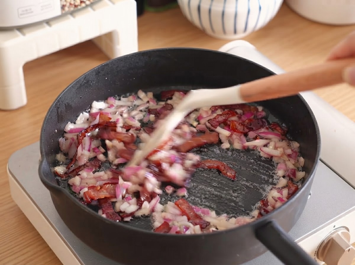 Ein Block Frischkäse liegt in einer Rührschüssel aus Keramik.