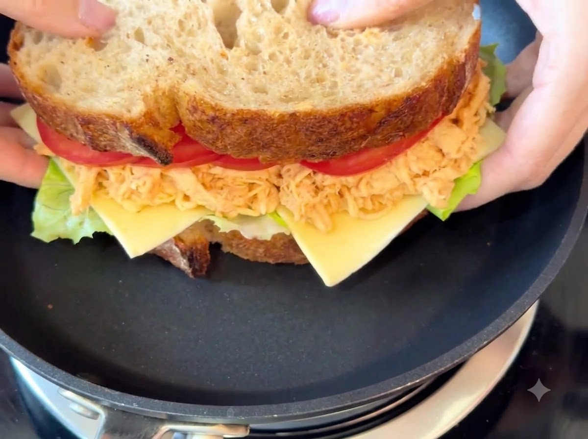 Das komplette Sandwich gart in einer schwarzen Bratpfanne bei schwacher Hitze.