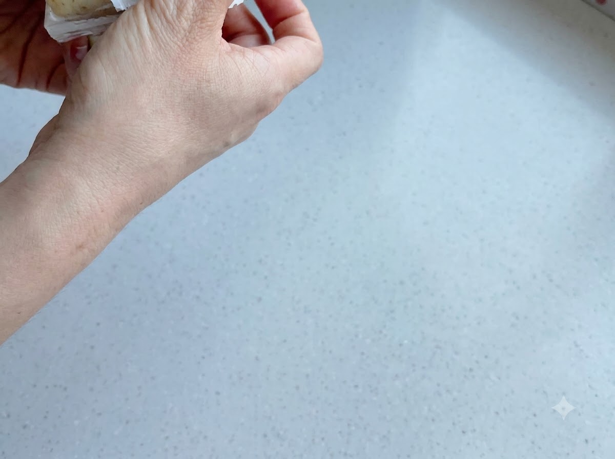 Schwarzes Pfefferpulver und Mayonnaise werden auf gekochte Kartoffeln und Karotten in einer Schüssel gestreut.