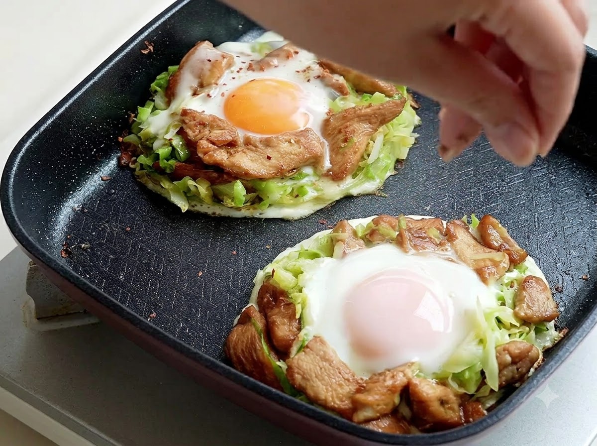 Grillgewürz wird von oben auf die gekochten Frittataportionen in der Pfanne gestreut.
