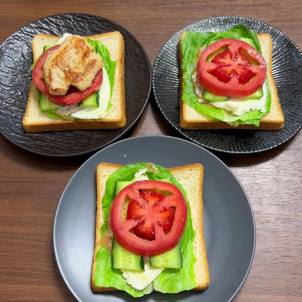 Vollkornbrot-Schichten, belegt mit Salat, Ei, Gurke und dicken Scheiben frischer Tomate.