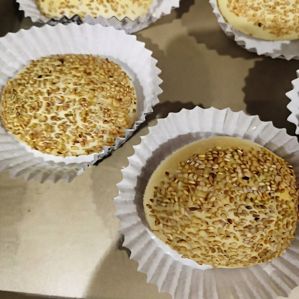 Burger-Patties braten in einzelnen Abschnitten einer Vierfächerpfanne auf dem Herd.