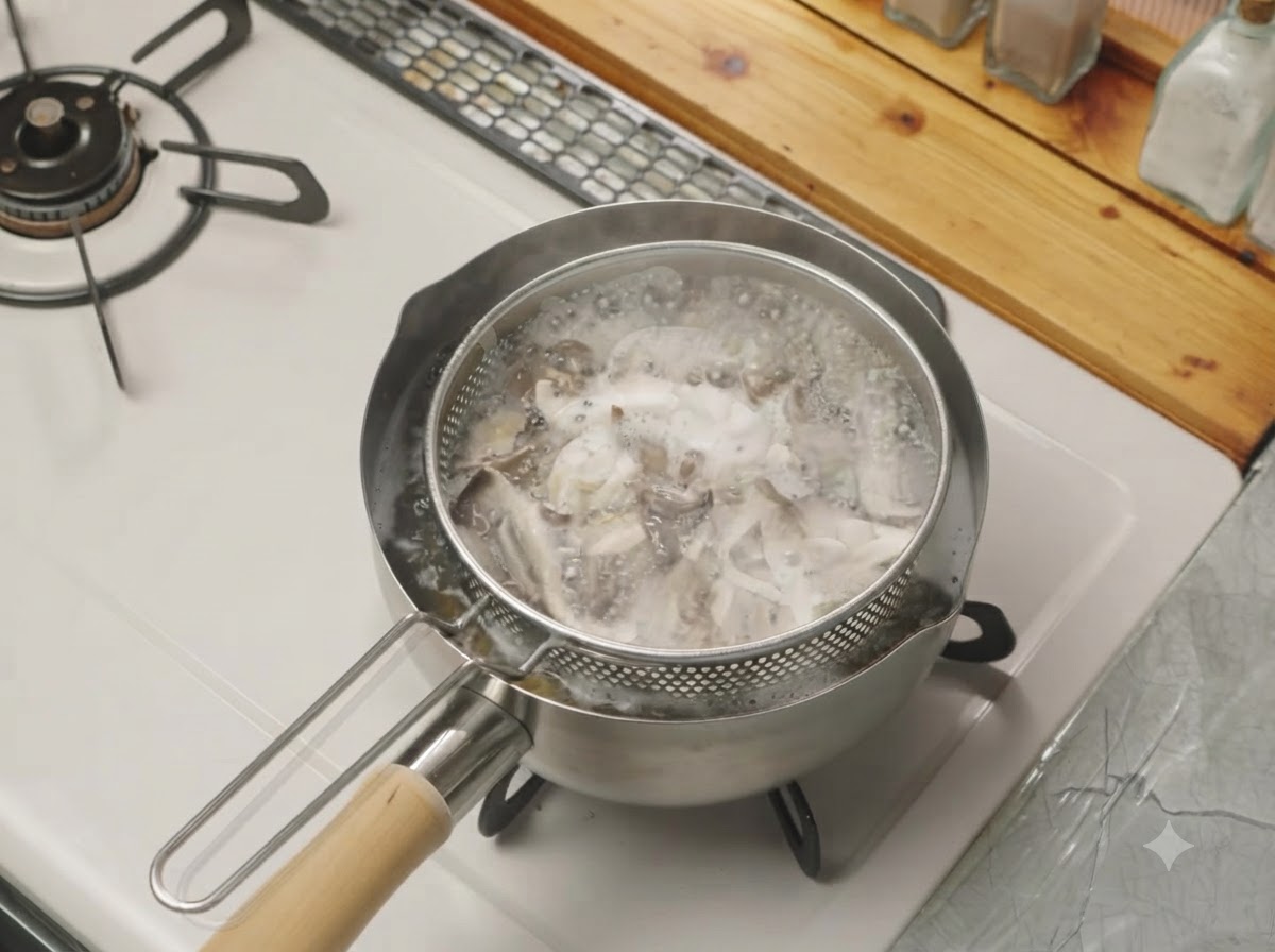 Gezupfte Pilze kochen in einem Siebeinsatz in einem Topf mit Wasser auf dem Herd.
