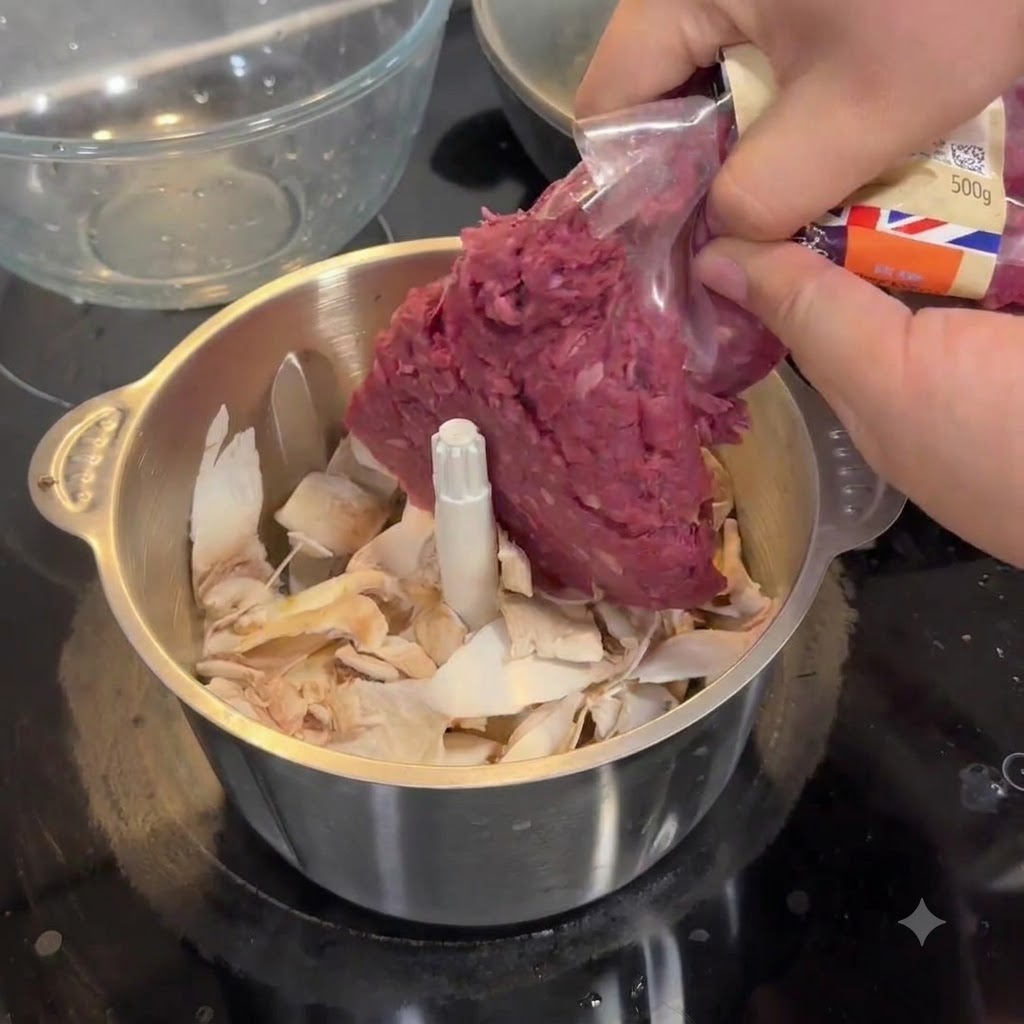 Hände drücken rohes Rinderhackfleisch aus einer Plastikverpackung in eine Küchenmaschine mit Pilzteilen.