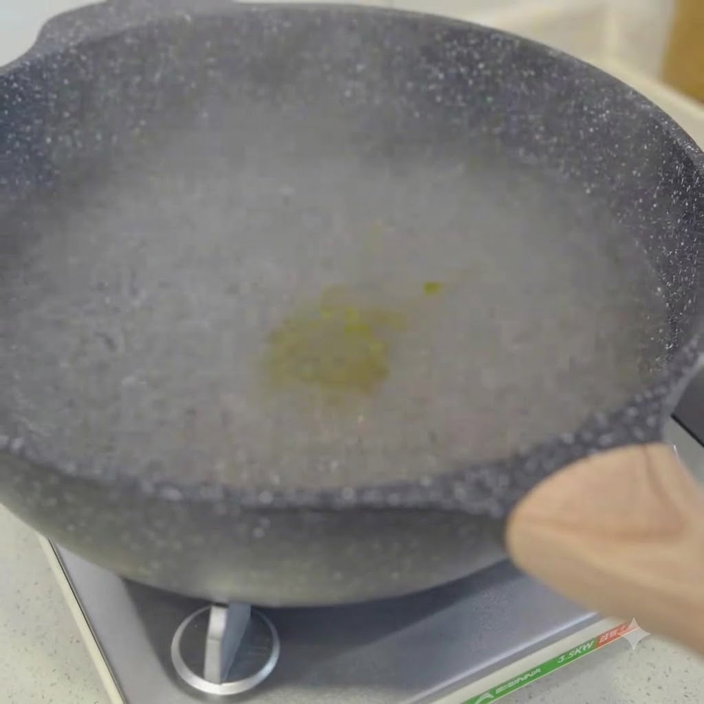 Spaghetti kochen in einem Topf mit kochendem Wasser und werden mit Stäbchen umgerührt.
