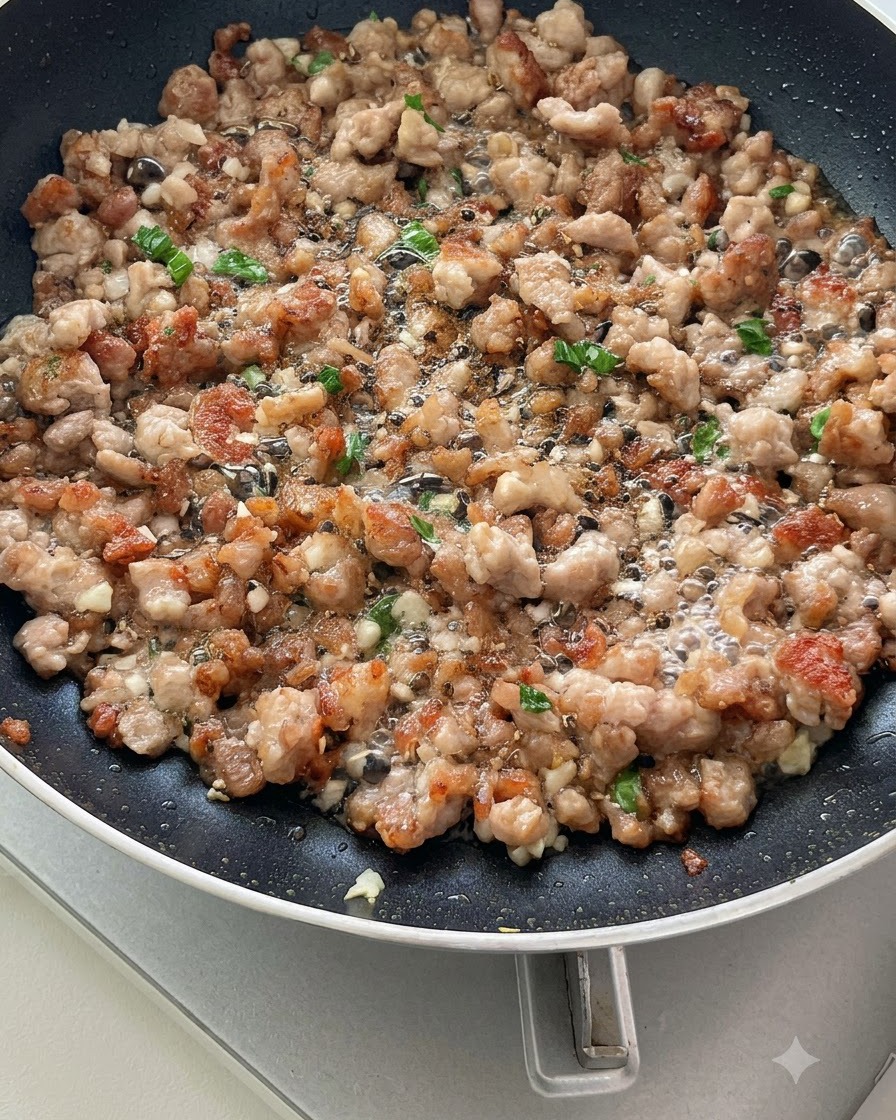 Geschnittene Tomaten werden zusammen mit Hackfleisch und Aromaten in einer Pfanne angebraten und beginnen, Saft abzugeben.