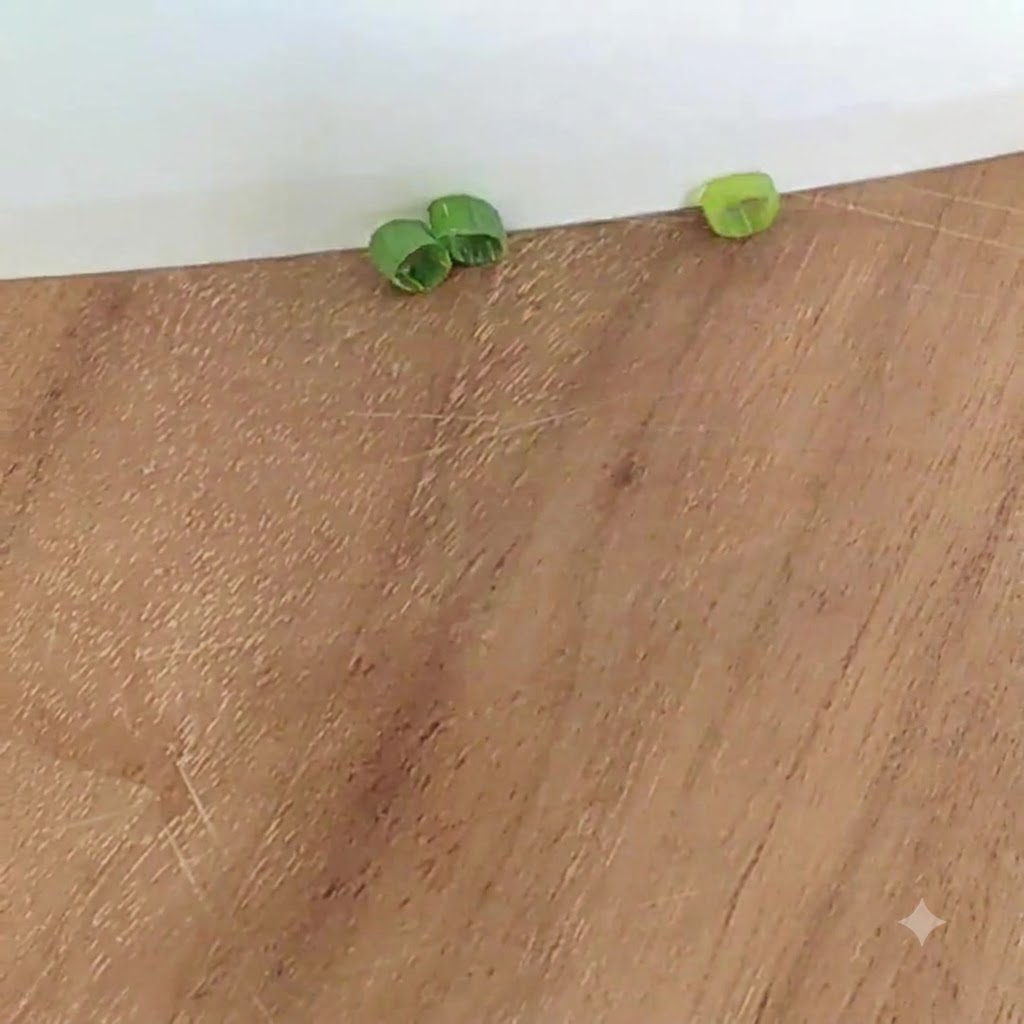 Frühlingszwiebelscheiben auf einem Holzschneidebrett.