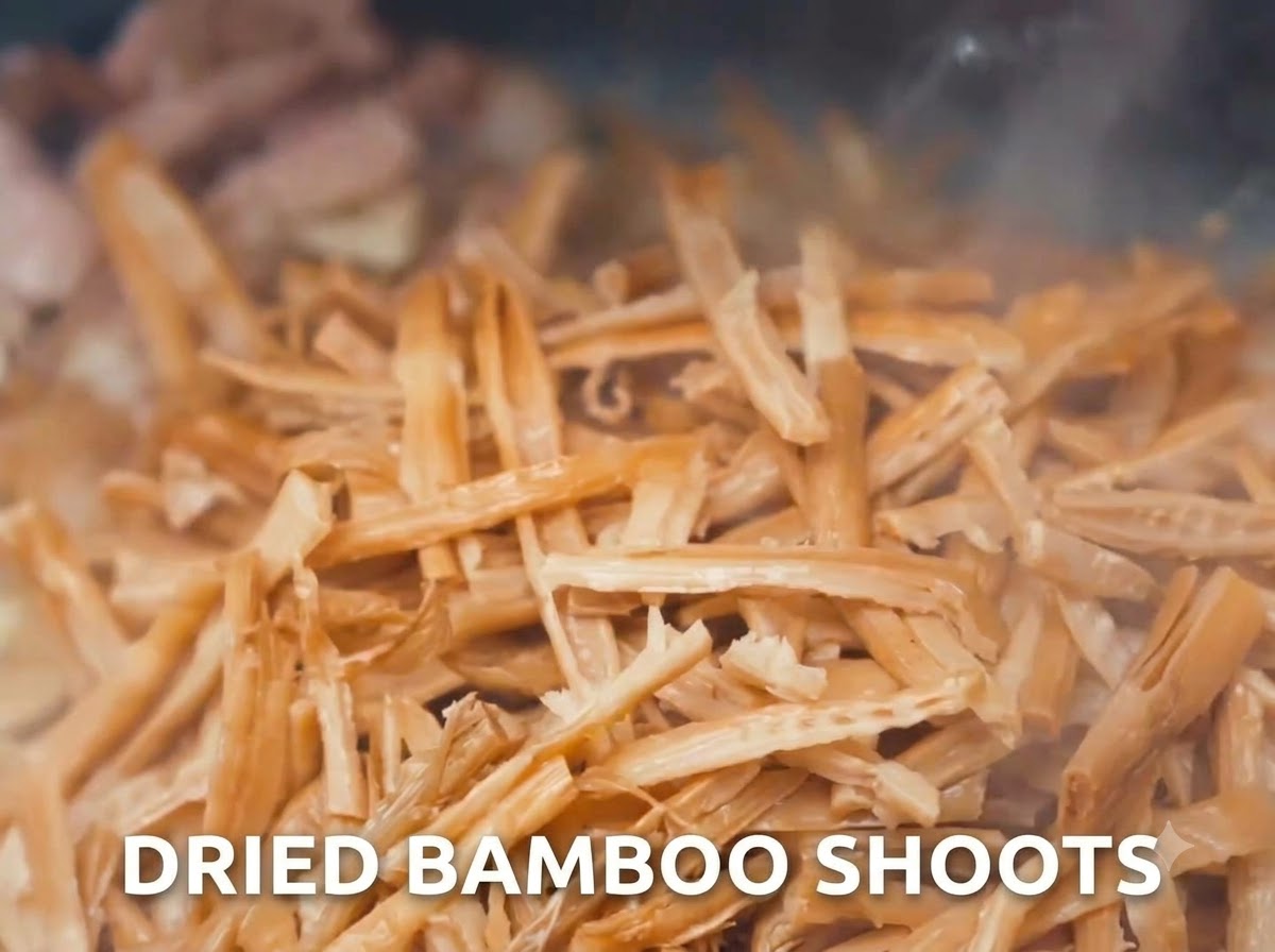 Getrocknete Bambussprossen und Fleisch werden in einem Wok gebraten.