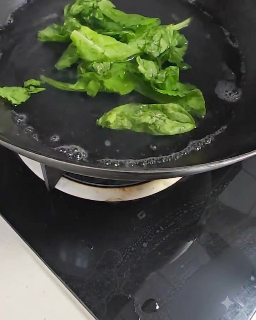 Frische, grüne Pak Choi-Blätter kochen in einem Topf mit sprudelndem Wasser auf einem Herd.