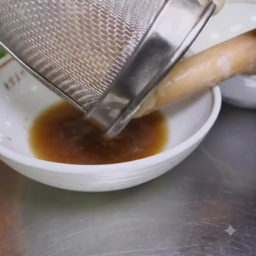 Gekochte Ramen-Nudeln werden aus einem Sieb in eine Schüssel mit Würze gegossen.