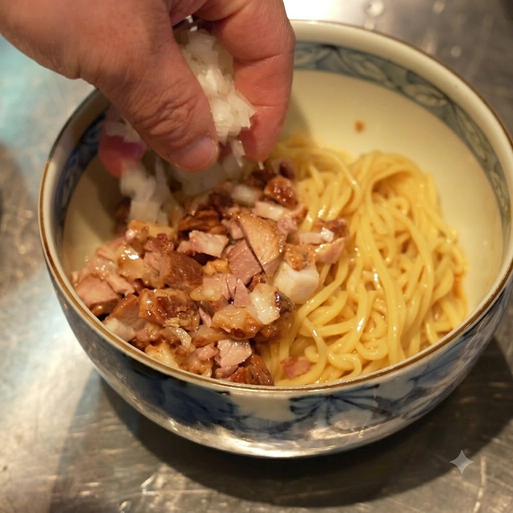 Eine Hand streut gewürfelte weiße Zwiebeln auf die Schüssel mit Nudeln und Chashu.