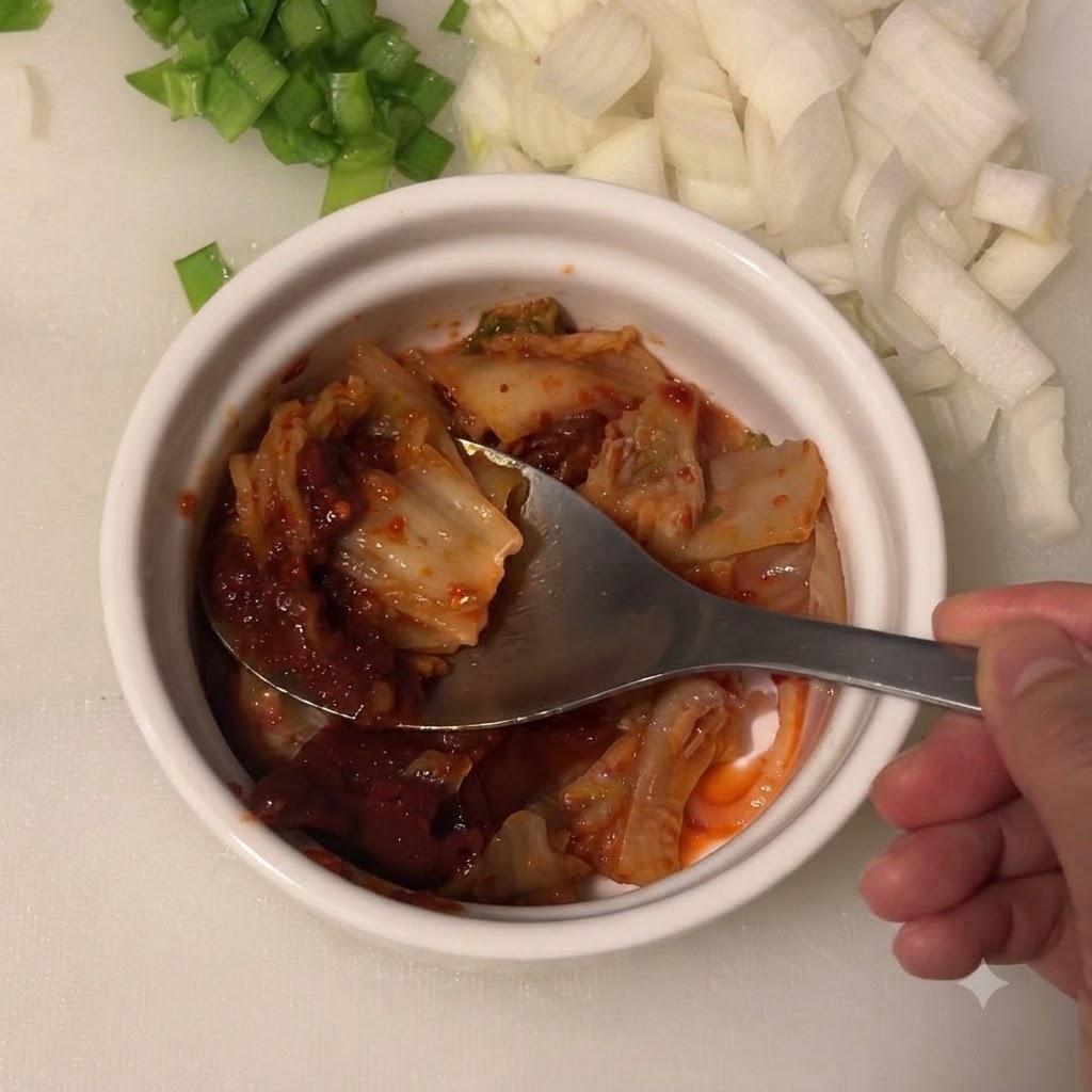 Helle Sojasauce wird in die Schüssel mit Kimchi und koreanischer Chilipaste gegeben.