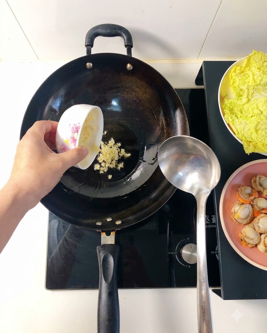 Gehackter Knoblauch brät in heißem Öl in einem Wok, wird goldbraun und setzt Aroma frei.