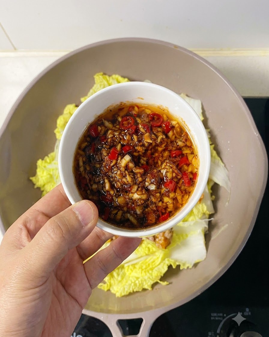 Herzhafte Knoblauch-Chili-Sauce wird großzügig über das angeordnete Jakobsmuschelfleisch gelöffelt.