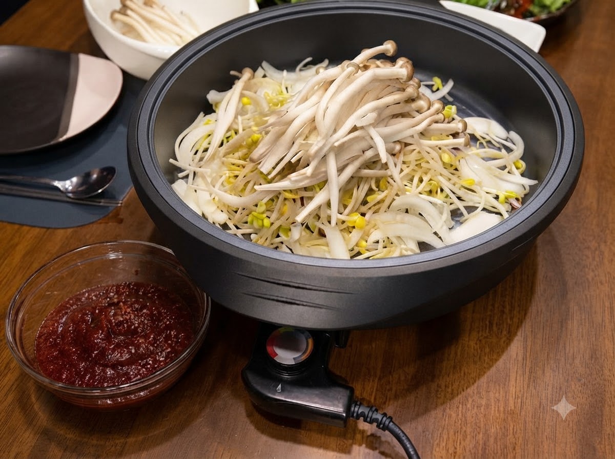 Weiße Shimeji-Pilze, aufgetürmt auf den Bohnensprossen und Zwiebeln in der Elektropfanne.
