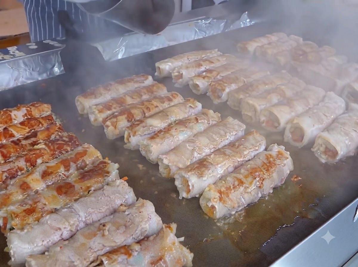 Eine Scheibe gelber Käse wird auf die Kimchischicht über die vorbereiteten Fleischrollen gelegt.